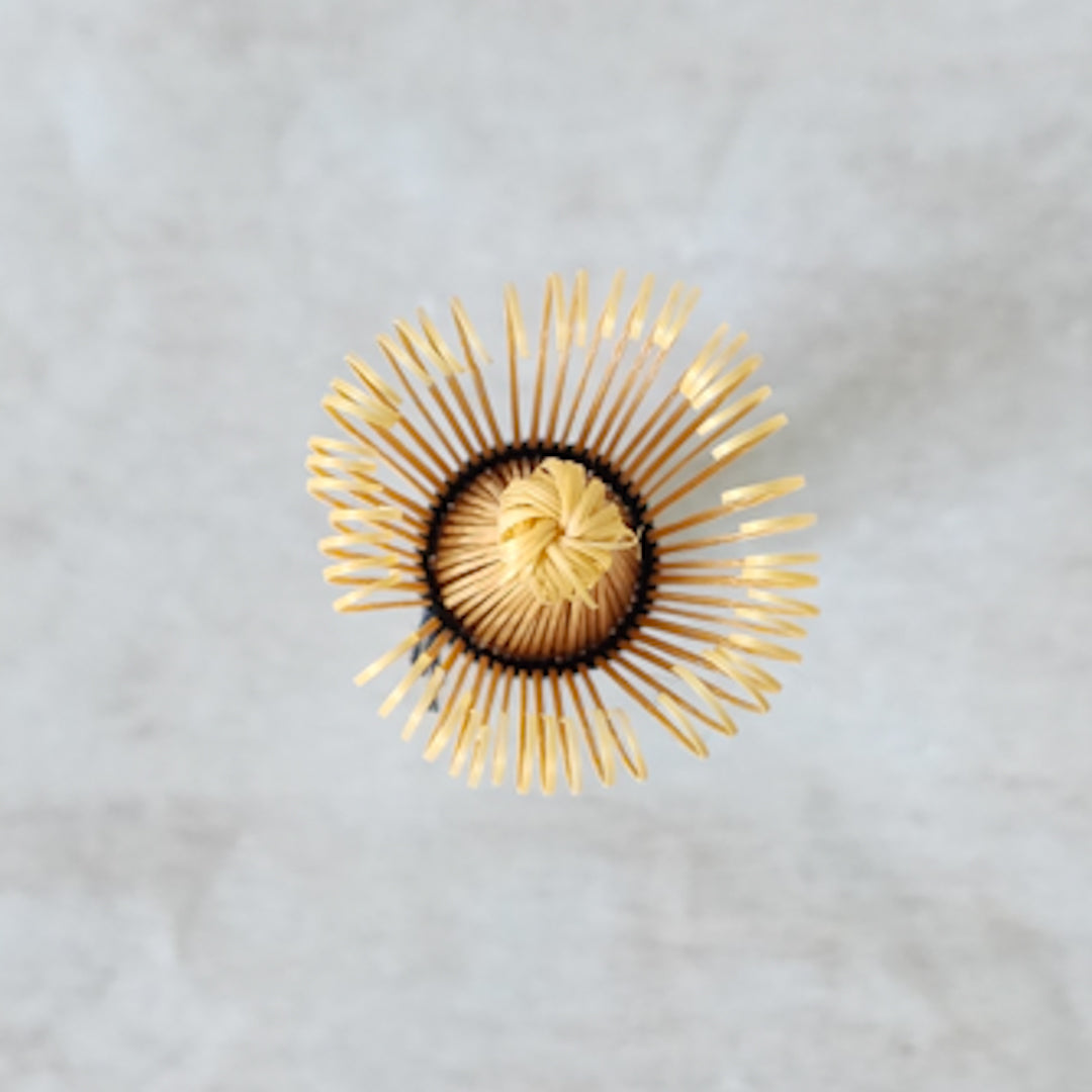 Premium matcha whisk (chasen) coated in vibrant green matcha, perfect for Japanese tea rituals