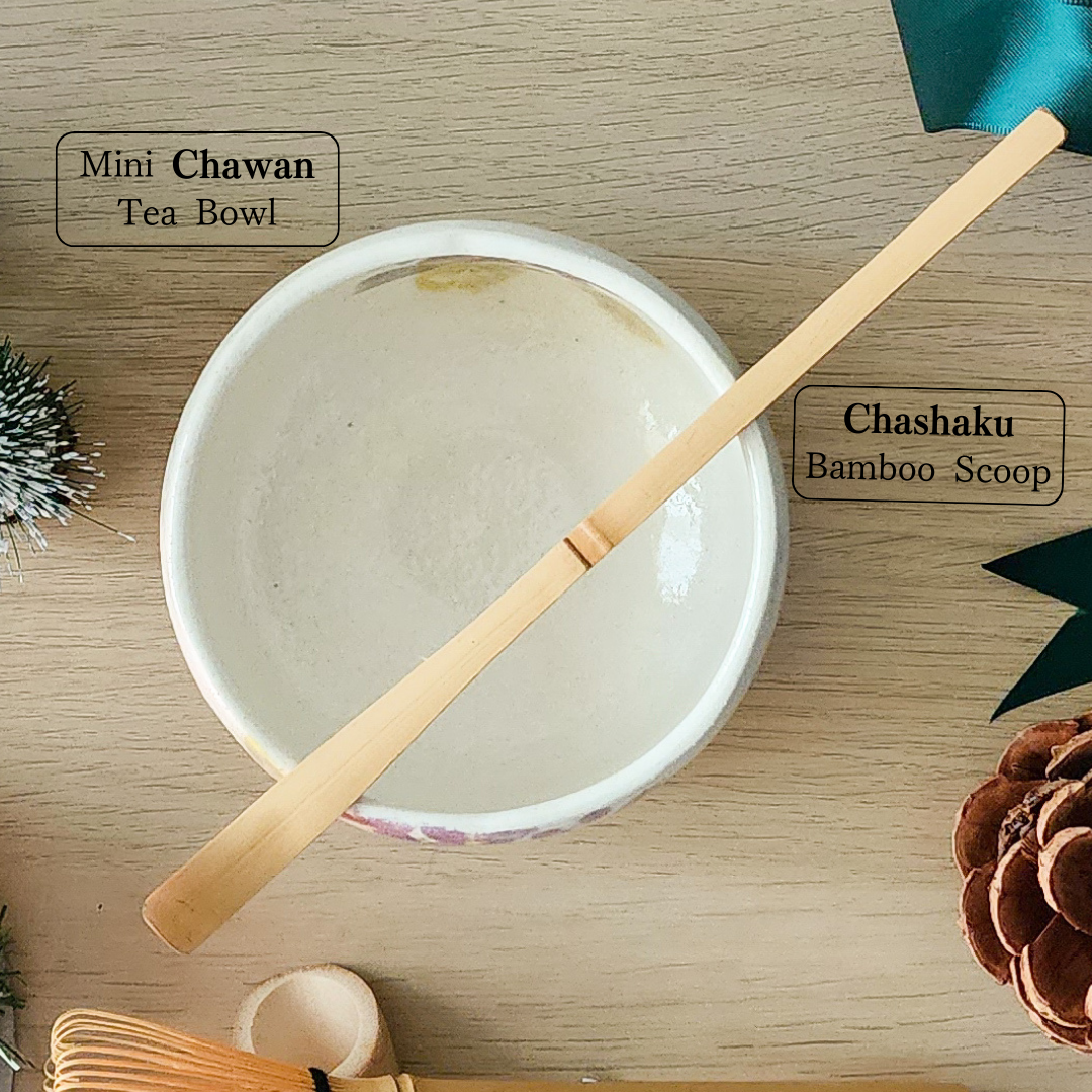 Traditional Japanese matcha bamboo scoop (chashaku) resting on a mini chawan (tea bowl), essential for matcha measurement